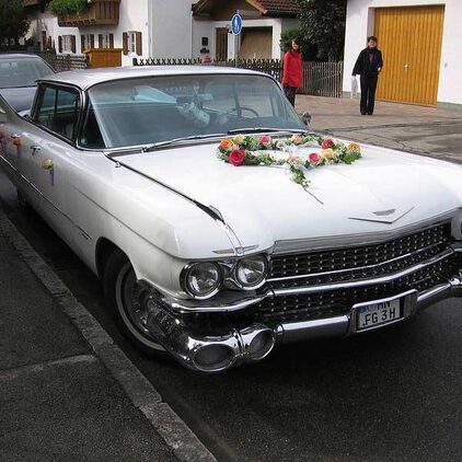Weißer Cadillac-Oldtimer mit Blumenschmuck auf der Motorhaube
