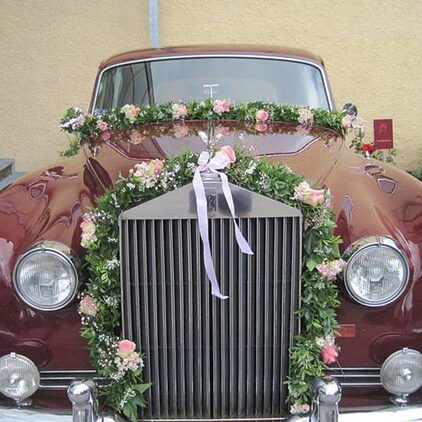 Rolls-Royce-Oldtimer mit einer Girlande aus Rosen und weißen Bändern