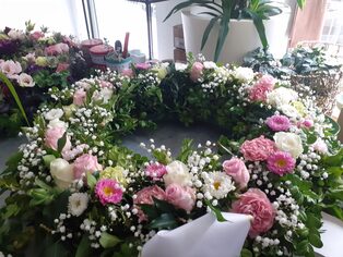 Trauerkranz aus rosafarbenen Nelken, Rosen und Schleierkraut