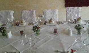 Festlich eingedeckte Tafel mit kleinen Blumengestecken und Windlichtern