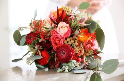 Brautstrauß in Rot und Orange mit Ranunkeln, Rosen und Eukalyptus