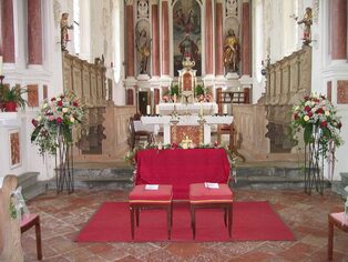 Kirchenaltar mit üppigem Blumenschmuck in Rosa und Weiß