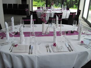Festtafel mit violettem Tischläufer und kleinen Blütengestecken