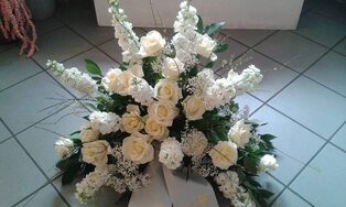 Trauergesteck aus weißem Rittersporn, Rosen und Nelken