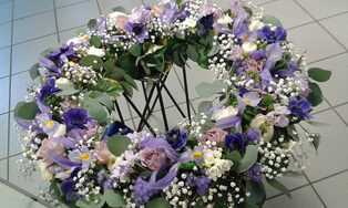 Trauerkranz aus violetten und weißen Blüten mit Schleierkraut