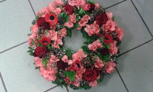 Trauerkranz aus rosafarbenen Nelken und Gerbera