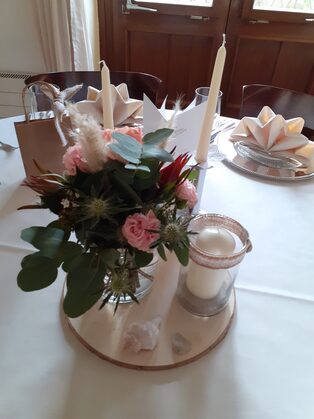 Tischgesteck aus Rosen und Eukalyptus mit Windlichtern